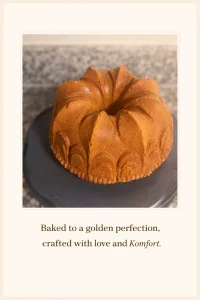 Golden brown bundt-style pound cake on a dark cake stand