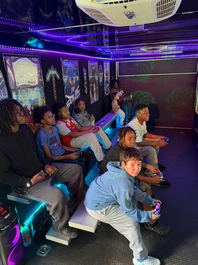 Kids playing inside of a mobile gaming bus.